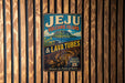 A vintage-style metal sign advertising Jeju Volcanic Island and lava tubes, with a tropical island landscape and a tunnel-like structure in the center.