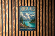 A vintage-style metal sign for Joffre Lakes, a scenic Canadian park, is displayed on a wooden wall.