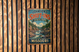 A vintage metal sign for Johnson's Shut-Ins State Park in Missouri, featuring a scenic illustration of a river and mountains.