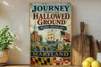 A vintage-style metal sign with the text "Journey Through Hallowed Ground" and "National Heritage Area" hangs on a wall, featuring an illustration of a ship, a bridge, and a monument.