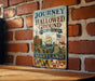 A vintage metal sign with the text "Journey Through Hallowed Ground" and "National Heritage Area" hangs on a brick wall, depicting a ship and a bridge in the background.
