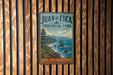 A vintage-style metal sign for Juan de Fuca Provincial Park in British Columbia, Canada, featuring a scenic coastal landscape with rocky cliffs, pine trees, and a body of water.