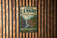 A vintage-style metal sign for Judge C.R. Magney State Park in Minnesota, featuring a scenic image of a waterfall surrounded by pine trees.