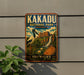 A vintage-style sign for Kakadu National Park in Australia, featuring an illustration of a bird, a waterfall, and a landscape with a rock formation.