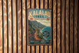 A vintage metal sign for the Kalalau Trail in Kauai, Hawaii, featuring a scenic mountain landscape and a trail leading to the ocean.