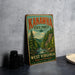 A vintage-style metal sign for Kanawha State Forest, featuring a scenic illustration of the forest and a river, is displayed on a gray concrete surface.