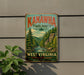 A vintage-style metal sign for Kanawha State Forest in West Virginia, featuring a scenic illustration of a forest landscape with a river and mountains.