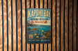 A vintage metal sign for the Kapoho Bay Marine Reserve in Hawaii, featuring a turtle and tropical plants, is displayed on a wooden wall.