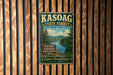 A vintage-style metal sign for the Kasoag State Forest in New York, featuring a scenic landscape with a lake and mountains.