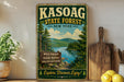 A vintage-style sign for the Kasoag State Forest in New York, featuring a scenic landscape with a lake and pine trees.