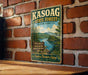 A vintage-style metal sign for the Kasoag State Forest in New York, featuring a scenic landscape with a lake and mountains.