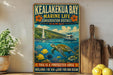 A vintage-style metal sign for the Kealakua Bay Marine Life Conservation District in Hawaii, featuring a colorful illustration of a turtle swimming among tropical fish and coral.