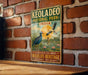 A vintage-style metal sign for Keoladeo National Park in India, featuring a bird illustration and text promoting the park as a "paradise for birds" and a "wildlife heritage".