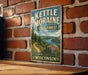 A vintage metal sign for Kettle Moraine State Forest in Wisconsin, featuring a scenic landscape with a river, trees, and a path leading through the forest.