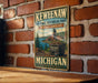 A vintage-style metal sign for Keweenaw National Historical Park, featuring a scenic landscape with a coal mine and a river.