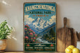 A vintage-style poster of Khangchenzong National Park in India, featuring a mountain landscape with a river and flowers, is displayed on a wall next to a wooden cutting board and some potted plants.