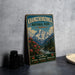 A vintage-style metal sign for Khangchenzong National Park, India, featuring a mountain landscape with flowers and a river.