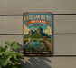 A vintage-style metal sign with a scenic landscape of mountains, water, and wildlife, including a crane, is displayed on a wall.