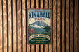 A vintage-style metal sign welcoming visitors to Kinabalu Park, Malaysia, with a mountain landscape and text indicating the park's focus on nature, adventure, and discovery.