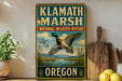 A vintage-style sign for Klath Marsh National Wildlife Refuge in Oregon, featuring a duck in flight and a scenic landscape.