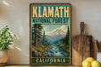 A vintage-style poster of Klamath National Forest in California, featuring a scenic mountain landscape with a river and pine trees.