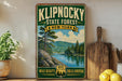 A vintage-style poster advertising Klipnocky State Forest in New York, featuring a scenic landscape with pine trees, a lake, and mountains.