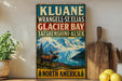 A vintage-style sign for Kluane, Wrangell-St. Elias, Glacier Bay, Tatshenshini-Alsek, and North America, featuring a moose in a scenic landscape.