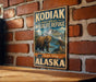 A vintage-style metal sign for the Kodak National Wildlife Refuge in Alaska, featuring a bear and an eagle in a scenic landscape.