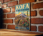 A vintage-style metal sign for the Kofa National Wildlife Refuge in Arizona, featuring a desert landscape with a ram and cactus.