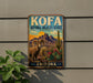 A metal sign with a vintage-style illustration of a bighorn sheep and desert landscape, mounted on a wall.