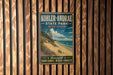 A vintage-style metal sign for Kohler-Andrae State Park in Wisconsin, featuring a scenic beach landscape with sand dunes and a blue sky with clouds.