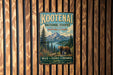 A vintage metal sign for Kootenai National Forest in Montana and Idaho, featuring a scenic image of a bear in the wilderness.