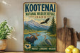 A vintage-style sign for the Kootenai National Wildlife Refuge in Idaho, featuring an illustration of moose, eagle, and other wildlife in a scenic landscape.