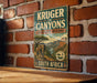 A vintage-style metal sign with the text "Kruger to Canyon" and "Biosphere Reserve" is displayed on a brick wall.