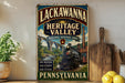 a vintage-style sign for the Lackawanna Heritage Valley National Heritage Area in Pennsylvania, with a train engine and bridge in the background.