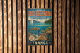 A vintage metal sign for the Lagoon of New Caledonia, featuring a seascape with a sailboat, coral reefs, and marine life.