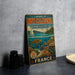 A vintage-style metal sign advertising the "Lagouns of New Caledonia" and "Reef Diversity and Associated Ecosystems" in France, featuring an illustration of a coral reef and marine life.