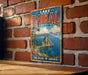 A vintage metal sign with the text "Lake Baikal Russia" and "The Pearl of Siberia" is displayed on a brick wall.
