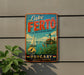 A vintage-style sign for Lake Fertö, the jewel of Western Hungary, featuring a sailboat and a lighthouse, is displayed on a wall next to a plant.