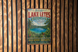 A vintage-style metal sign advertising Lake Letés, Vanuatu, featuring a tropical landscape with a lake and palm trees.