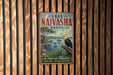 A vintage-style metal sign for Lake Naivasha, Kenya, featuring an illustration of a bird perched on a tree branch overlooking a body of water.