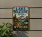 A vintage-style metal sign for the Lake Solitude Trail in Wyoming, featuring a scenic mountain landscape and a trail sign.