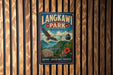 A vintage-style metal sign for Langkawi Park in Malaysia, featuring an eagle in flight and a cable car, mounted on a wooden wall.