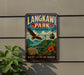 A vintage-style metal sign for Langkawi Park in Malaysia, featuring an eagle in flight and a suspension bridge in the background.
