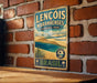 A vintage-style metal sign for Lençois Maranhenses National Park in Brazil, featuring a beach scene and palm trees.
