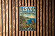 A vintage-style sign for "Lesvos Island Park" in Greece, featuring an owl perched on a cliff overlooking the sea.