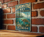A vintage-style metal sign for Lignum vitae Key Aquatic Preserve in Florida, featuring an illustration of a turtle swimming in the ocean.