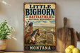 A vintage-style metal sign for Little Big Horn Battlefield National Monument in Montana, featuring an illustration of a Native American man on horseback.