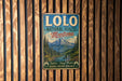 A vintage metal sign for Lolo National Forest, Montana, featuring a scenic mountain landscape with pine trees and a river.