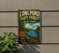 A vintage-style metal sign for Long Pond State Forest in New York, featuring a scenic illustration of a lake, forest, and canoe.